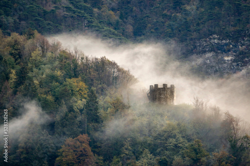 una nebbia avvolge boschi e torre picotta a tolmezzo