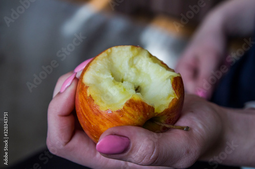 nadgryzione jabłko trzymane w dłoni