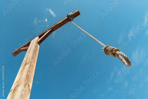 Gallows against blue sky. Hanging rope as a way to punishment