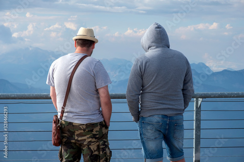 Tourists are looking on beautiful view of the mountains with cloudy sky at view point on Tahtali mountain in Turkey.