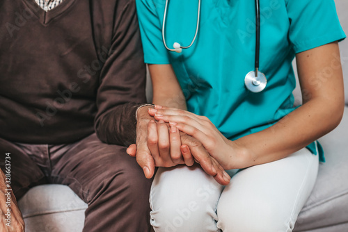 Nurse holding hand of senior man in rest home. Doctor helping old patient with Alzheimer's disease. Shot of a caregiver helping a senior man. Care Worker Helping Senior Man