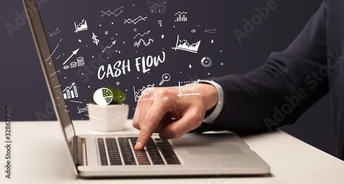 Businessman working on laptop with CASH FLOW inscription, modern business concept