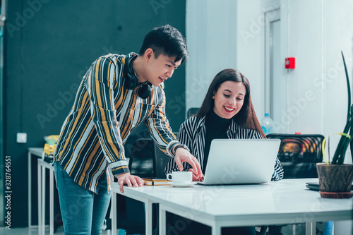 Friendly young man helping his coworker stock photo