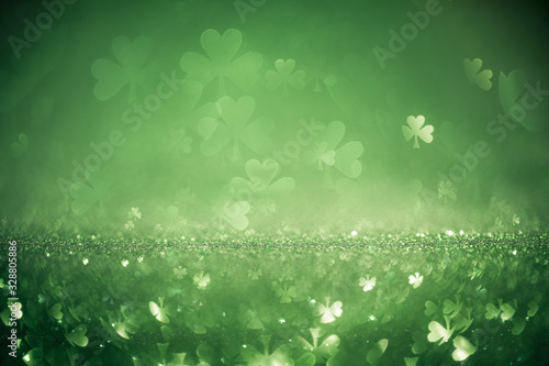Green St Patricks day background with sparkling shamrock shapes