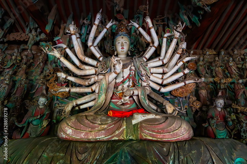 Fine ancient figure of buddhist goddess with 24 arms. Altar statue made in wood located in Shuanglin Temple (or Zhongdu Temple), outskirts Pingyao Old City, Shanxi province, China