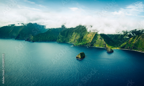 Beautiful Aerial View of Tropical Island Paradise Nature Scene of Maui Hawaii On Clear Sunny Day with Vibrant Blue Ocean Water and Waves and Lush Green Mountain Scenic Landscape with Big Rock in Sea