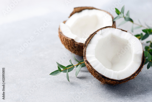 Halved coconut on concrete background with copy space for text or design elements