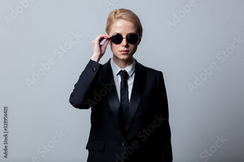 Style businesswoman in a classic black business suit and sunglasses