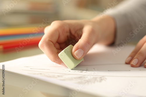 Woman using rubber erasing drawing on a desk