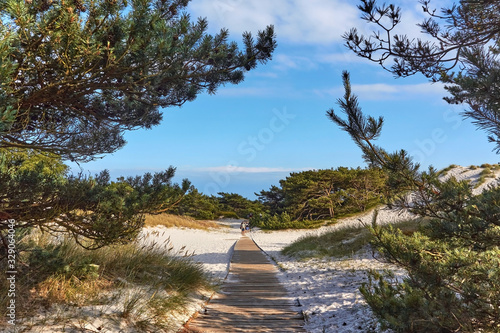 Wooden boardwalk through sand dune leading to a beach in Dueodde, Bornholm island, Denmark