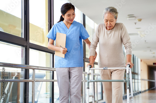 asian old woman walking with a walker in rehab center