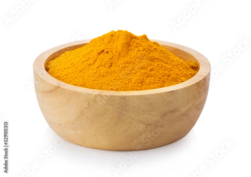 turmeric powder in wood bowl on white background