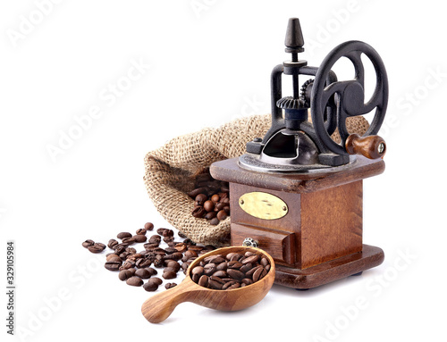 Coffee mill with Coffee beans in a wooden spoon on white background.