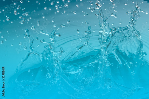 Drop of water on blue background.Water splash wallpaper.