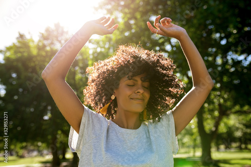 Young woman dancing in a park on a sunny afternoon