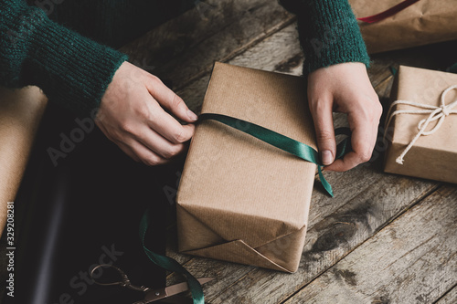 Woman making beautiful Christmas gift at table