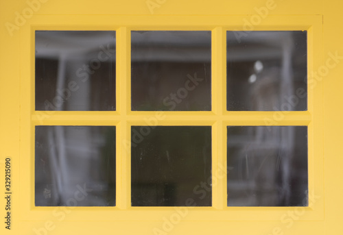 Decorative transom window above a Customizable Fiberglass Prehung Front Door w/ yellow frame and grilles dividing it into six squares in a newly restored house up and coming Washington DC neighborhood
