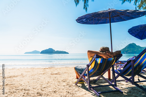 Summer lifestyle Asian man traveler relaxing on beach chair in front of vacation exotic beach, Attraction place leisure tourist travel Hua Hin Thailand holiday trip, Tourism beautiful destination Asia