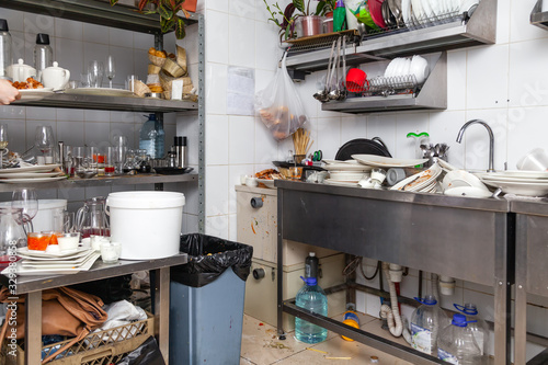 Restaraunt kitchen full of dirty dishes, crockery, tableware