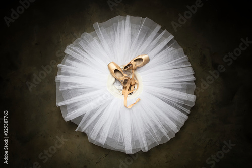Ballet shoes with ribbons on a white tutu in a dance studio
