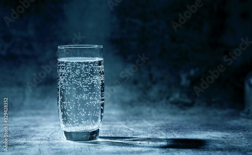 Glass of sparkling water on the grey background