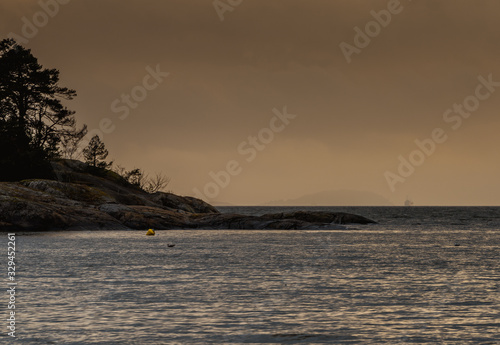 Mgliste pomarańczowe niebo nad Oslofjordem w marcowy dzień