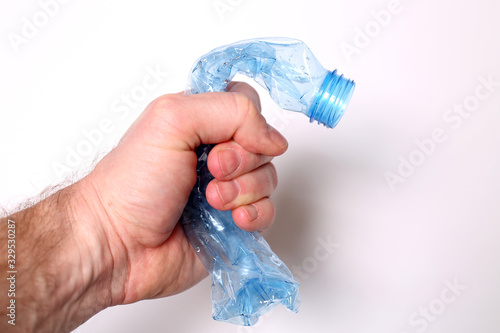Ręka zgniata plastikową butelkę pet