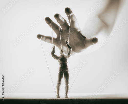 Concept of control. Marionette in human hand. Black and white image.