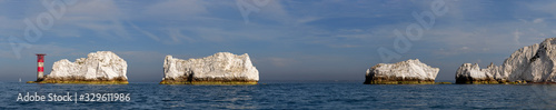 The Needles with the lighthouse on the Isle of Wight white cliffs on blue sea and blue sky