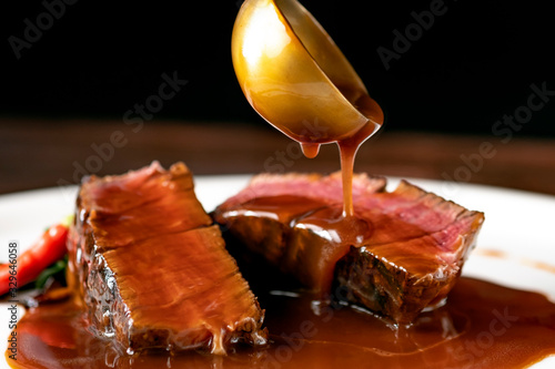 Grilled beef Steak filet Mignon medium rare pour demi-glace sauce