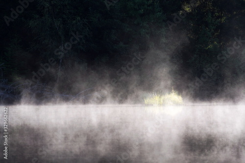 Morning haze over surface of the Pohorsky pond know as Jiricka reservoir near Pohorska Ves, Novohradske Mountains, Cesky Krumlov District, South Bohemian Region, Czech Repubic, sunny summer day