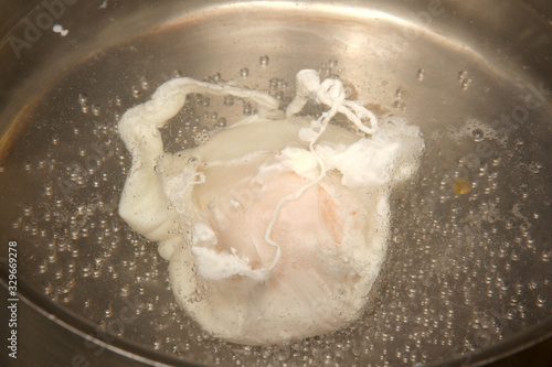 An egg poaching in boiling water