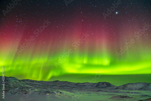 Spectacular red and green Aurora Borealis Northern Lights in Greenland