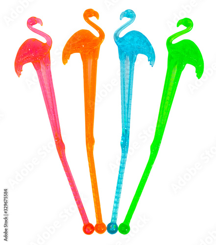 Isolated red, green, orange and blue plastic flamingo cocktail stirrers.