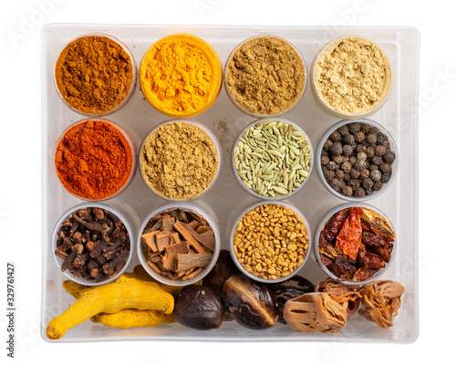 Colorful spices in plastic containers isolated on white. Indian spice set. Top view.