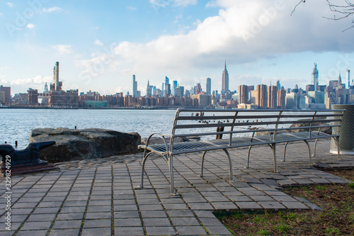 Empty Bench at Bushwick Inlet Park in Williamsburg Brooklyn New York along the East River with a view of the Manhattan Skyline