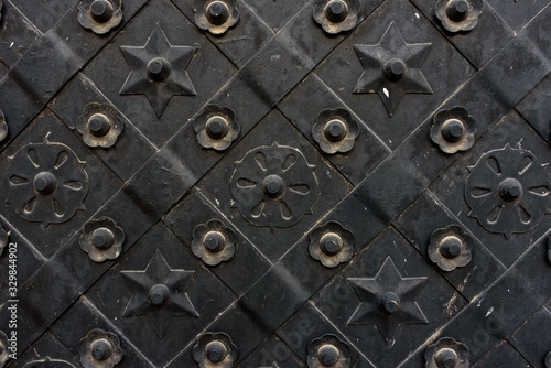 Black forged door, rhombus symmetrical texture. Grunge black background