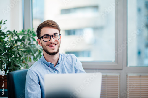 Young businessman in office working on laptop