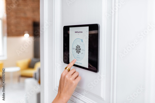 Controlling home ventilation or conditioning with a digital touch screen panel. Concept of wireless ventilation control and smart home