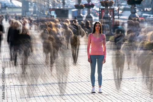 The young woman stands in the middle of crowded street