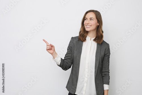 Beautiful businesswoman is looking happy and pointing at your product