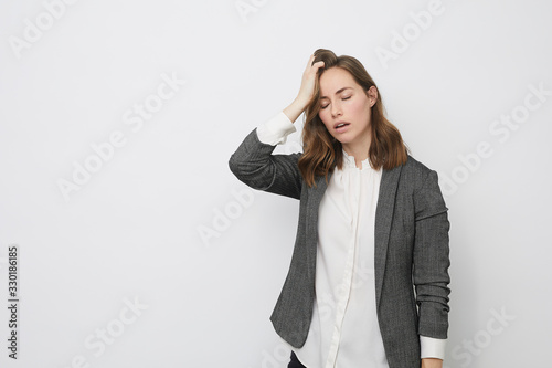 Businesswoman having her hand on her head while looking dejected