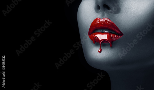 Red Lipstick dripping. Paint drips, lipgloss dripping from sexy lips, Blood liquid drops on beautiful model girl's mouth, creative abstract make-up. Beauty woman face makeup close up, vampire