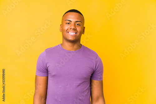 Young latin man isolated on yellow background happy, smiling and cheerful.