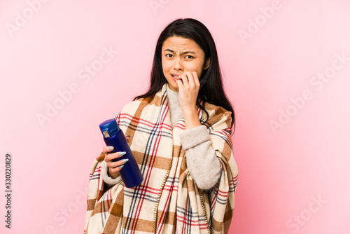 Young chinese woman doing a camping isolated on pink background shouting and holding palm near opened mouth.