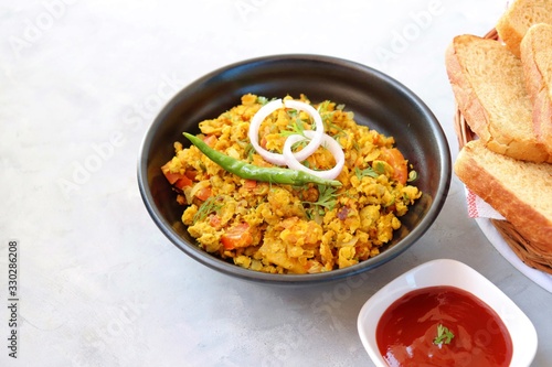Indian Breakfast Dish - Parsi Akuri or Anda Bhurji or Indian spicy scrambled eggs served with toasted brown bread & ketchup. Famous Indian street food. Ingredients background with copy space.