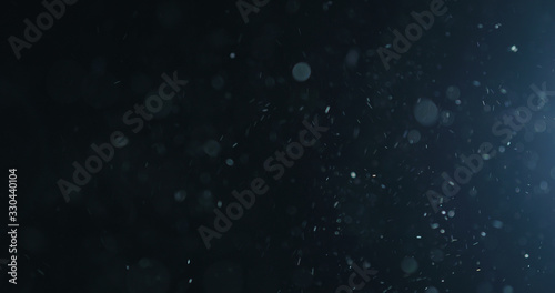 natural dust particles flow in air on black background