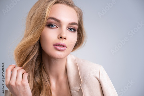 Beautiful face of an attractive model with blue eyes. Woman with beauty long brown hair and natural makeup. Closeup portrait of a caucasian female. Attractive fashion model. Beauty face of a blonde