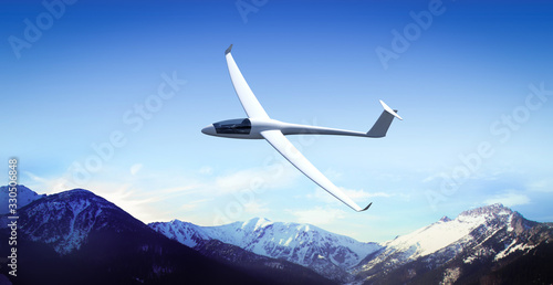 The glider is flying in the mountains