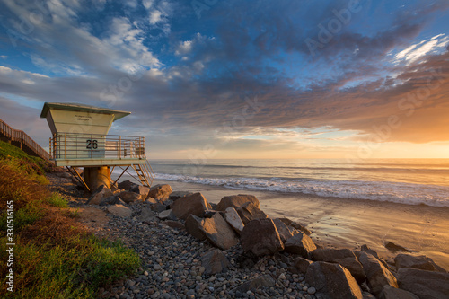 Sunset at beach od West Coast in California with lifeguard tower, USA